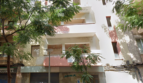 Vista exterior de un edificio residencial de varios pisos en Palma de Mallorca con balcones, fachada blanca y árboles.