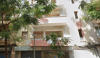 Vista exterior de un edificio residencial blanco en Palma de Mallorca con balcones y árboles enfrente.