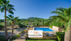 Zona exterior de la finca Felanitx: Piscina con tumbonas, palmeras y vistas a Sant Salvador