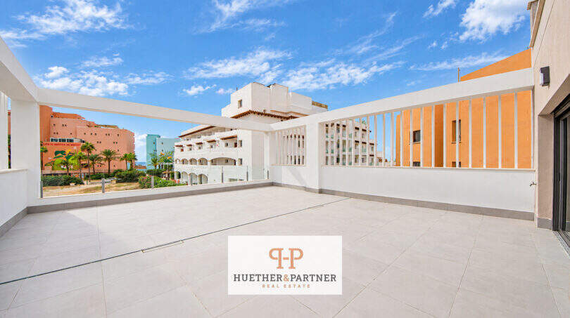 Geräumige Dachterrasse des Penthouse in Colonia de Sant Jordi mit weißem Geländer und Blick auf umliegende Gebäude