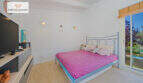 Helles Schlafzimmer mit Doppelbett, Holzboden, TV und Terrassenzugang zum Garten in Sa Ràpita.