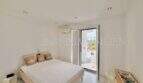 Helles Schlafzimmer mit Doppelbett, Klimaanlage und Balkontür mit Ausblick im Penthouse Cala Pi