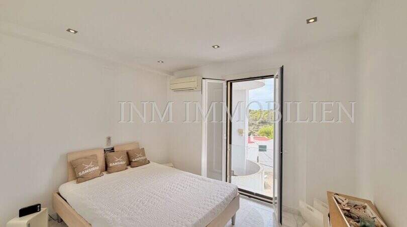 Helles Schlafzimmer mit Doppelbett, Klimaanlage und Balkontür mit Ausblick im Penthouse Cala Pi