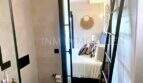 Modernes Badezimmer mit Blick ins Schlafzimmer, schwarze Akzente, helle Fliesen, Penthouse Playa de Palma