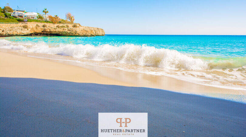 Türkisfarbenes Meer mit Sandstrand und Felsenküste in Cales de Mallorca, Nähe zur Wohnung mit Meerblick