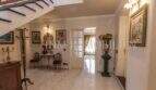 Eleganter Eingangsbereich der Villa in Marratxí mit Treppe, Marmorboden und klassischen Gemälden.