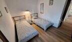 Helles Schlafzimmer mit zwei Einzelbetten, Holzboden und Wandleuchte in Wohnung in Port de Sóller