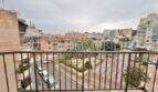 Balkon mit Metallgeländer und Blick auf Stadtplatz und umliegende Wohngebäude in Ses Cadenes, Palma