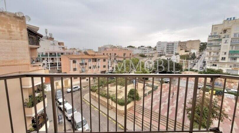 Balkon mit Metallgeländer und Blick auf Stadtplatz und umliegende Wohngebäude in Ses Cadenes, Palma