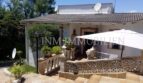 Vista exterior Villa Santa Ponsa: terraza con sombrilla, balaustrada, antenas parabólicas y jardín mediterráneo.