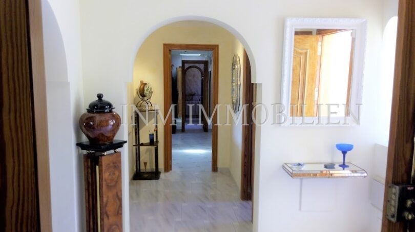 Entrada luminosa con pasillo de arco de medio punto, suelo de mármol y elementos decorativos en casa unifamiliar Santa Ponsa