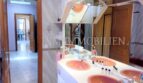 Baño espacioso con lavabo doble en rosa, espejo grande y vista al pasillo de la casa unifamiliar en Santa Ponsa.