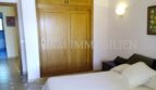 Dormitorio con cama doble, armario empotrado de madera y aplique de pared en casa unifamiliar Santa Ponsa
