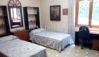 Dormitorio con dos camas individuales, escritorio, estantería y espejo en casa unifamiliar Santa Ponsa