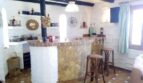 Barra rústica con piedra natural, vigas de madera y taburetes en casa unifamiliar Santa Ponsa