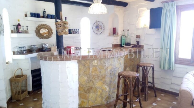 Barra rústica con piedra natural, vigas de madera y taburetes en casa unifamiliar Santa Ponsa