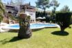 Außenansicht Villa Santa Ponsa: Gepflegter Garten mit Pool, Palme und mediterrane Architektur bei Sonnenschein.