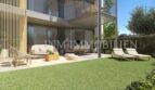 Amplia terraza de planta baja con jardín, muebles lounge y tumbonas del apartamento de nueva construcción en Palmanova
