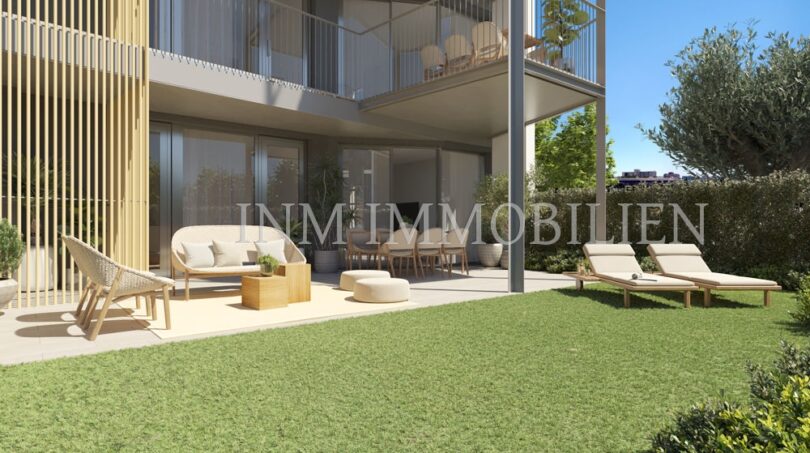 Amplia terraza de planta baja con jardín, muebles lounge y tumbonas del apartamento de nueva construcción en Palmanova