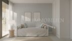 Dormitorio luminoso del apartamento áticos de nueva construcción en Palmanova con sofá, decoración de pared y acceso al balcón.