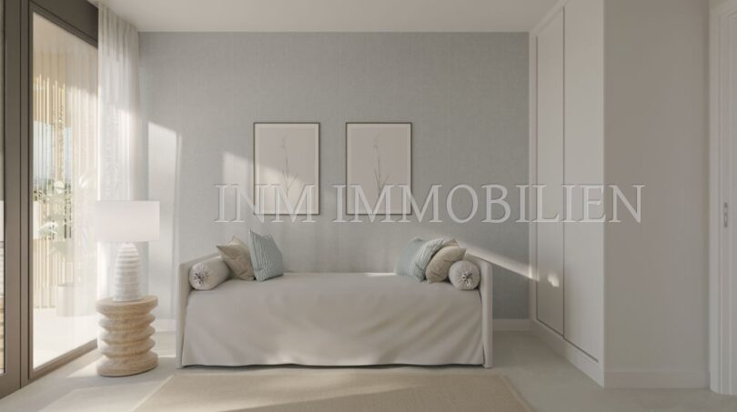 Dormitorio luminoso del apartamento áticos de nueva construcción en Palmanova con sofá, decoración de pared y acceso al balcón.