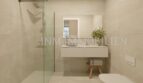 Moderno cuarto de baño del apartamento áticos de nueva construcción en Palmanova con ducha a nivel del suelo, lavabo flotante y azulejos claros.
