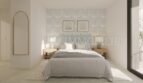 Dormitorio luminoso del apartamento áticos de nueva construcción en Palmanova con cama doble, muebles de madera y acento floral.