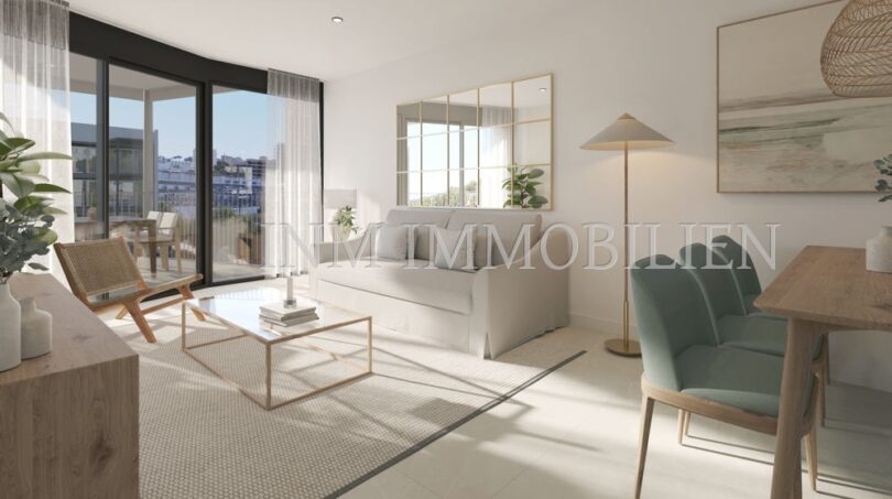 Luminosa sala de estar del apartamento áticos de nueva construcción en Palmanova con balcón, sofá moderno y mesa de comedor con sillas verdes.