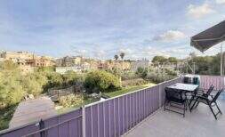 Sonnige Dachterrasse mit Sitzgruppe und Markise, Blick auf Garten und Ortschaft Porto Cristo