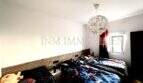 Schlafzimmer der Maisonette in Porto Cristo mit Doppelbett, Holzkopfteil und elegantem Kristalllüster