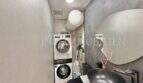 Modernes Badezimmer mit grauem Waschbecken, Spiegel und Waschmaschine in Maisonette-Wohnung Porto Cristo