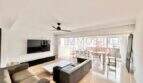 Helles Wohnzimmer mit Sofa, TV und Zugang zur Terrasse in strandnaher Wohnung in El Arenal, Palma