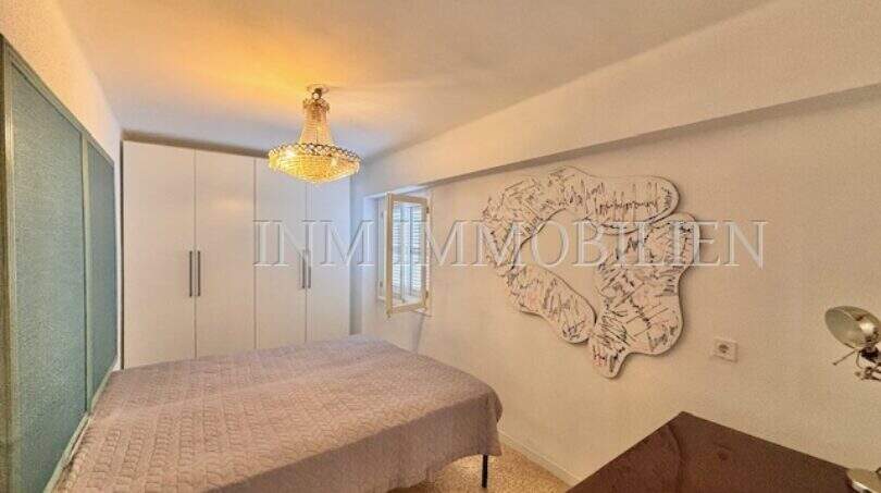 Schlafzimmer der Stranwohnung in El Arenal mit Kronleuchter, Einbauschrank und Wanddekoration