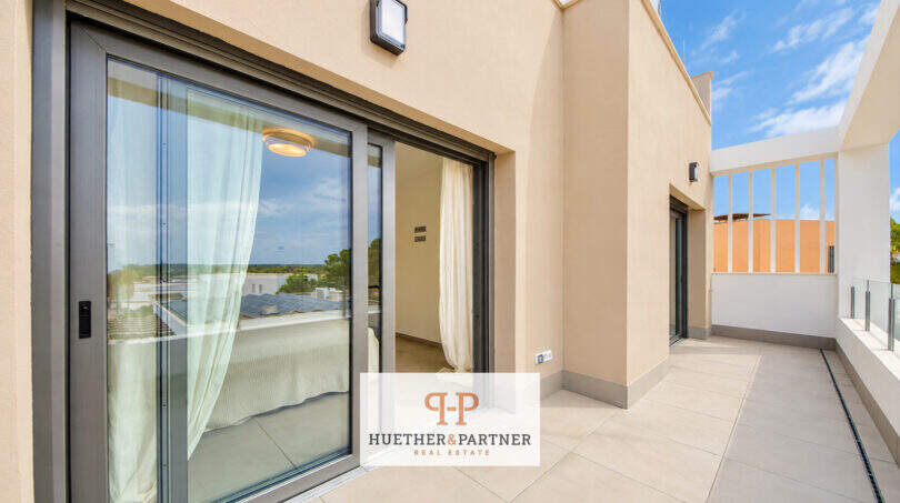Sonnige Dachterrasse des Penthouses in Colonia de Sant Jordi mit Glasschiebetür und Blick ins Grüne