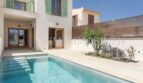 Exterior of the new build village house in Biniali with turquoise pool, terrace and green shutters