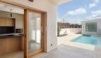 Covered terrace with pool view and modern kitchen area with wooden sliding door in new build village house Biniali