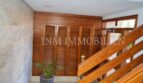 Entrance area with wooden paneling, louvered doors and marble walls in designer apartment in Palma de Mallorca.