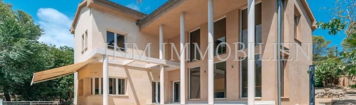 Exterior view of the villa in Calvià with large pool, terrace, columned veranda and Mediterranean garden.