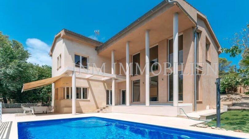 Exterior view of the villa in Calvià with large pool, terrace, columned veranda and Mediterranean garden.