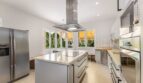 Modern kitchen of the villa in Cala Vinyes with kitchen island, granite countertops and stainless steel appliances