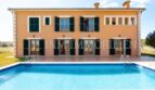 Vista exterior de la finca Santanyí: Casa señorial mediterránea con piscina, persianas verdes y jardín bien cuidado