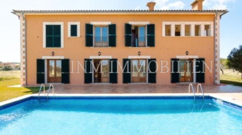 Vista exterior de la finca Santanyí: Casa señorial mediterránea con piscina, persianas verdes y jardín bien cuidado
