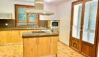 Cocina empotrada moderna con isla de cocina, campana extractora y suelo de terracota en la finca Santanyí