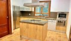 Cocina empotrada moderna con isla de cocina, electrodomésticos de acero inoxidable y suelo de terracota en la finca Santanyí