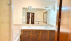 Elegante baño de la finca en Santanyí con lavabo doble, mueble de madera y espejo grande