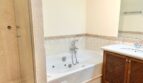 Baño de la finca en Santanyí con bañera de hidromasaje, ducha de cristal y mueble de madera
