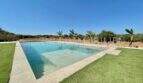 Large outdoor pool with stepped entry, well-maintained lawn and panoramic view of the landscape of the finca in Campos.