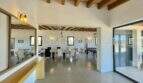 Open living-dining area with wooden beam ceiling, pool table and large glass front in high-quality finca, Campos
