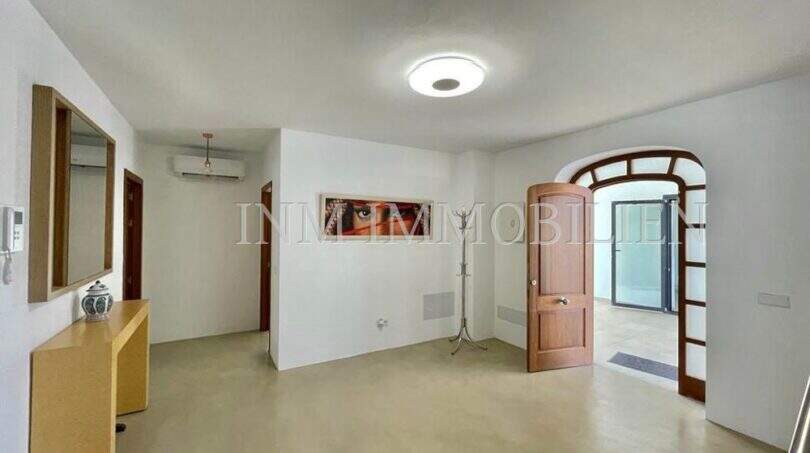 Bright entrance area of the finca in Campos with arched wooden door, air conditioning and Mediterranean charm.