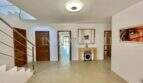 Bright entrance area of the finca in Campos with modern staircase, wooden doors and elegant concrete flooring.